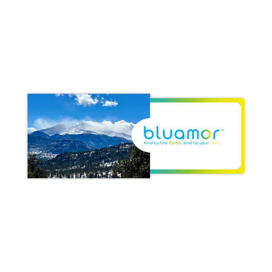 Bluamor Digital Gift Card displayed over a snowy mountain landscape, featuring a blue and green logo, emphasizing eco-conscious skincare gifting options.